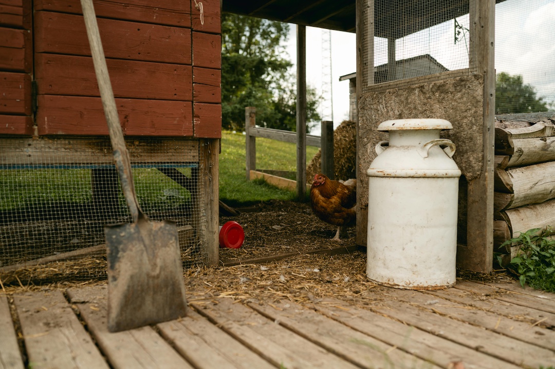 A chicken coop built in Ontario with a shovel leaning against it. 